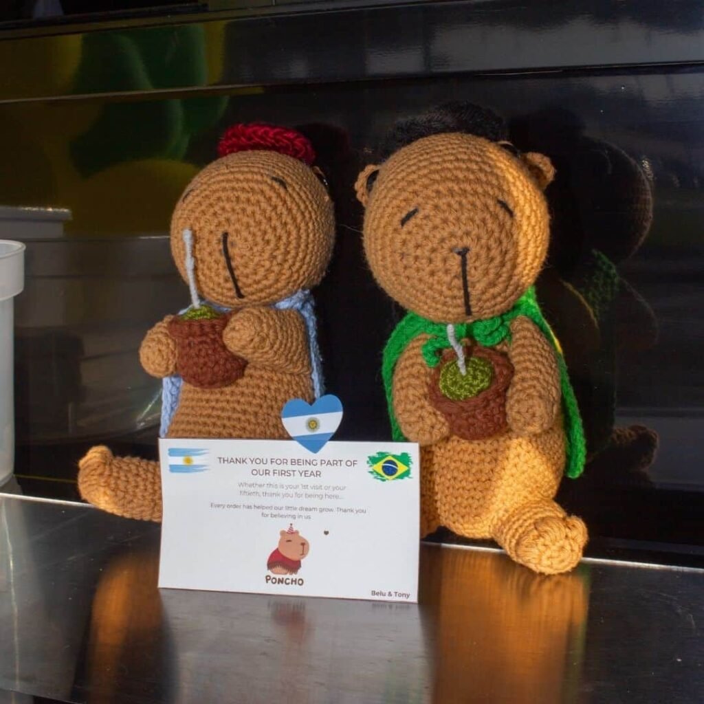 Handmade crochet capybaras holding South American flags.