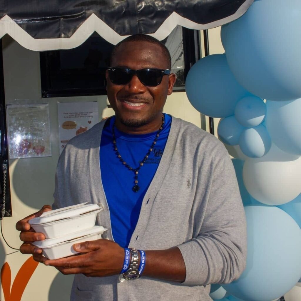 Man wearing sunglasses holding food truck takeout orders