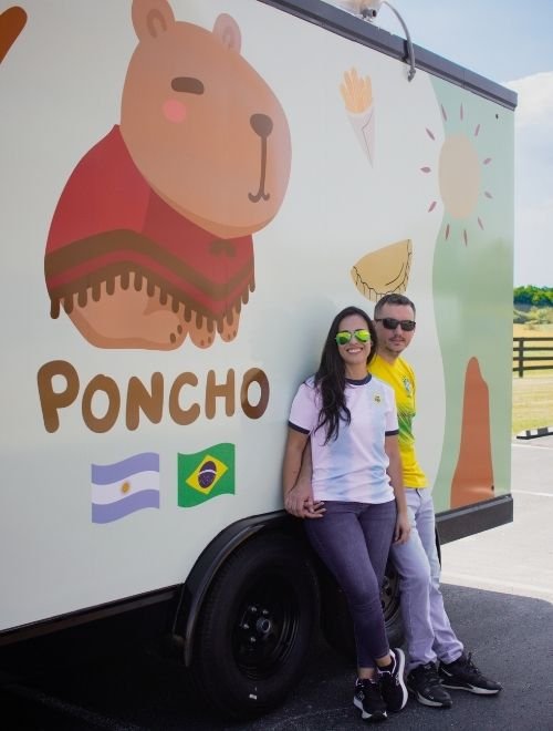 Poncho food truck owners standing outside their trailer in Lexington.