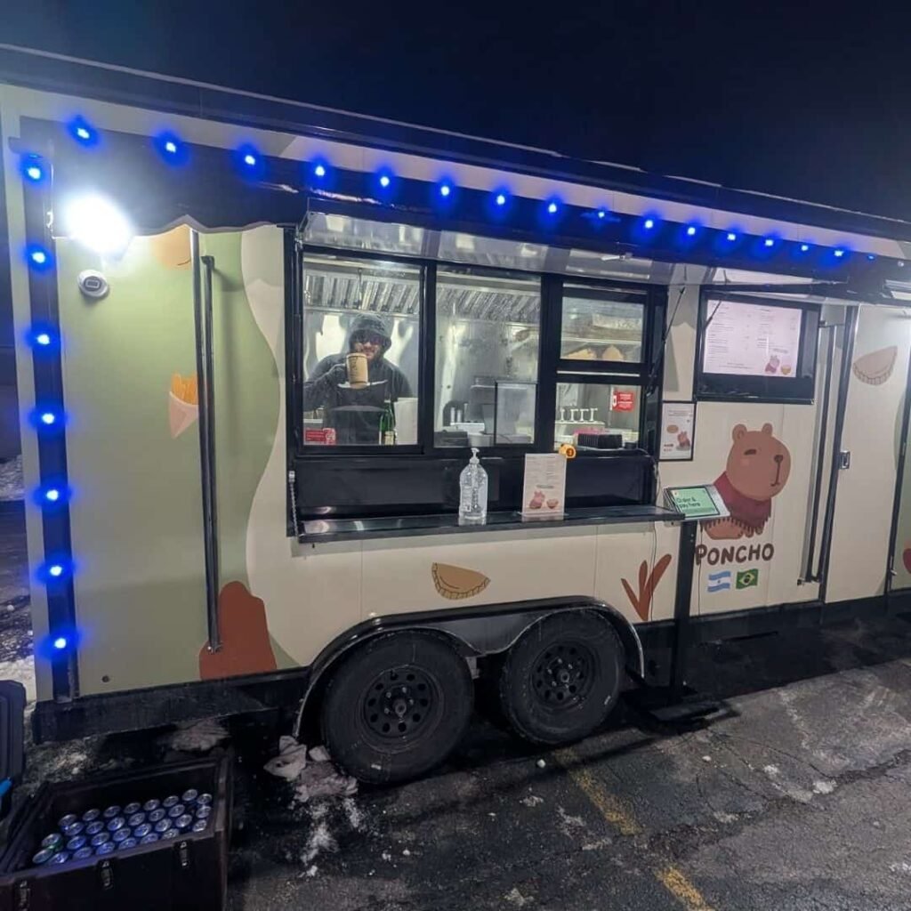 Poncho food truck illuminated at night during an evening event.