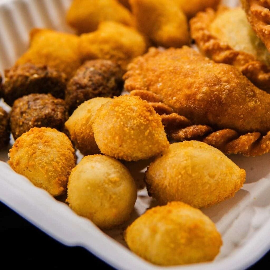 Close up of fried coxinhas and baked empanadas served fresh